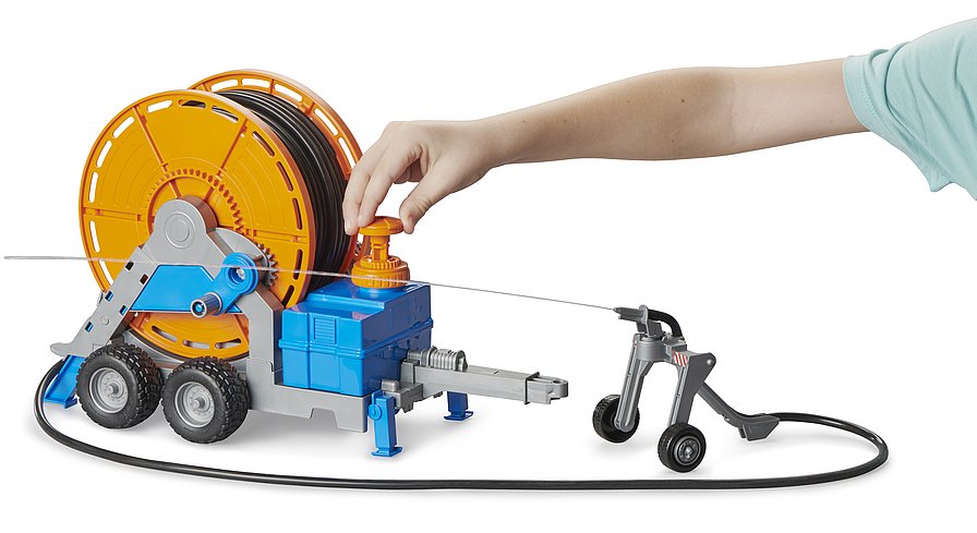 Kind handhabt die Kurbel zum Aufrollen des 1,8 Meter langen Schlauchs am Bruder Anhänger