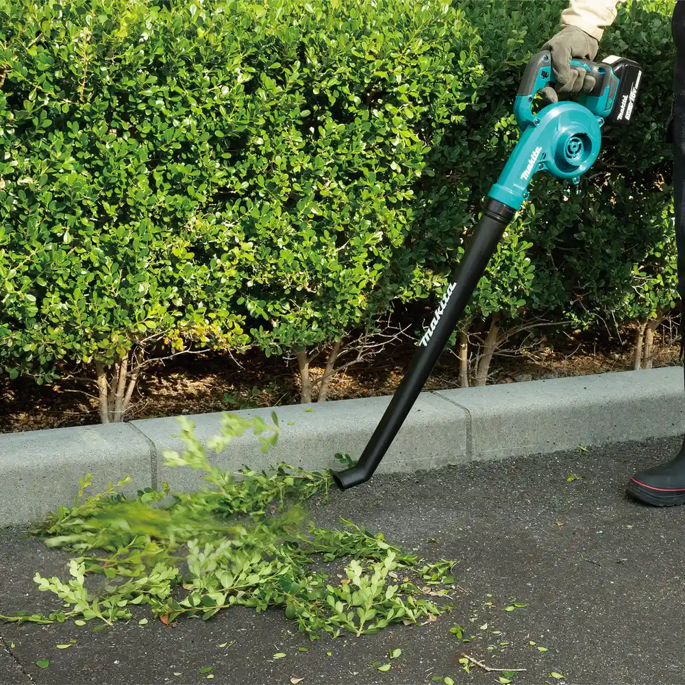 Makita DUB186Z Akku-Laubbläser im Einsatz an einer Hecke