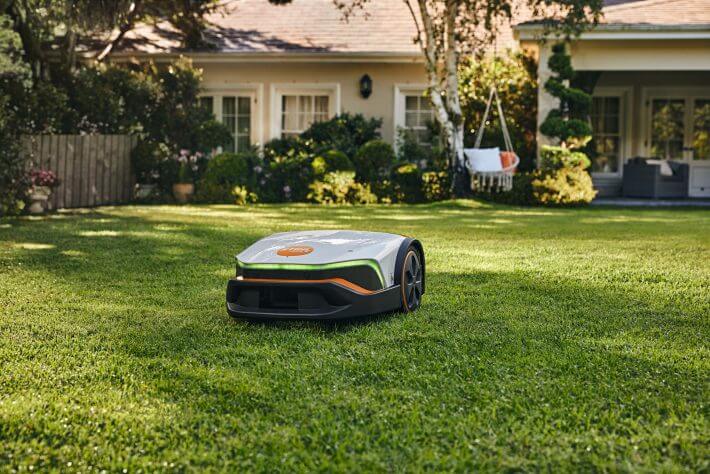 STIHL iMOW 6 Mähroboter im Garten vor einem Haus