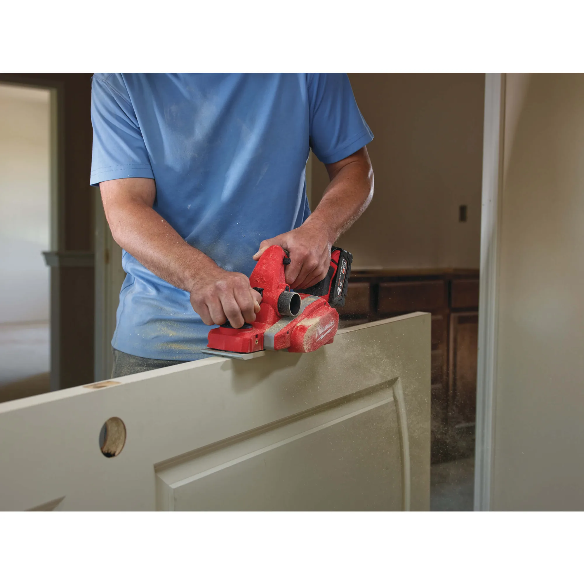 Mann hobelt mit dem Milwaukee M18 BP-0 eine Holzplatte
