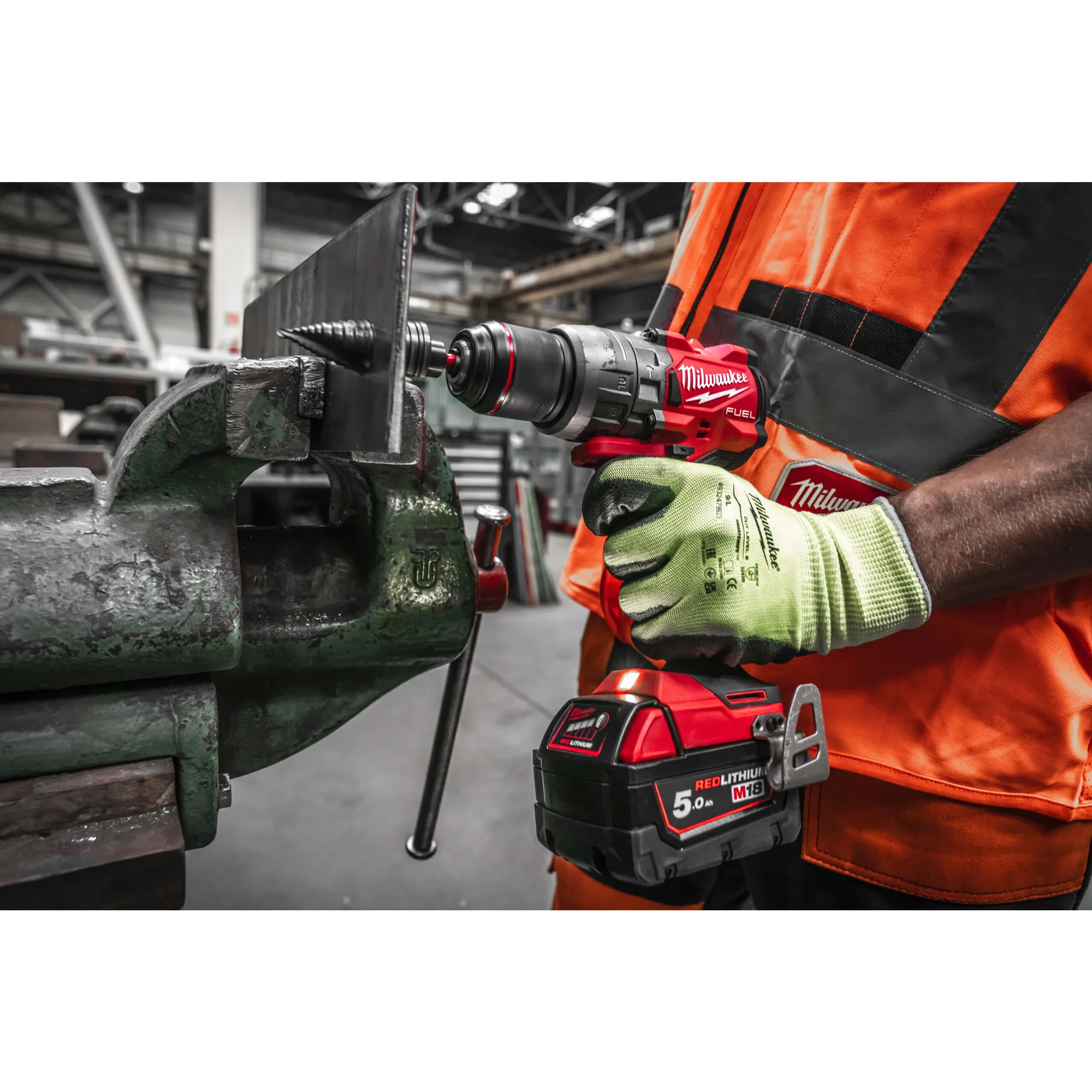 Mann bohrt mit dem Milwaukee M18 FUEL FPD3 ein Metallteil im Schraubstock