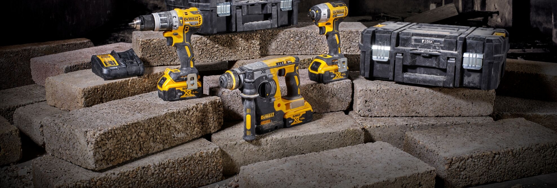 slider-example Gelb-schwarze DeWalt Akkuschrauber und Werkzeugkoffer auf Baustelle mit Betonsteinen