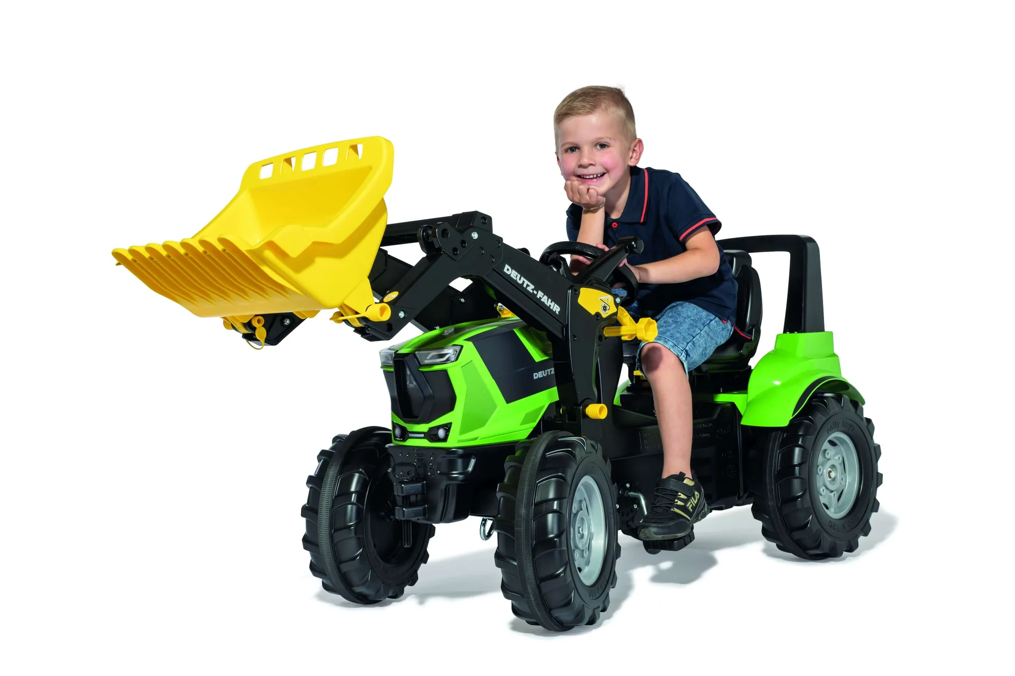 Junge fährt grünen Rolly Farmtrac Deutz-Fahr Trettraktor mit gelbem Frontlader