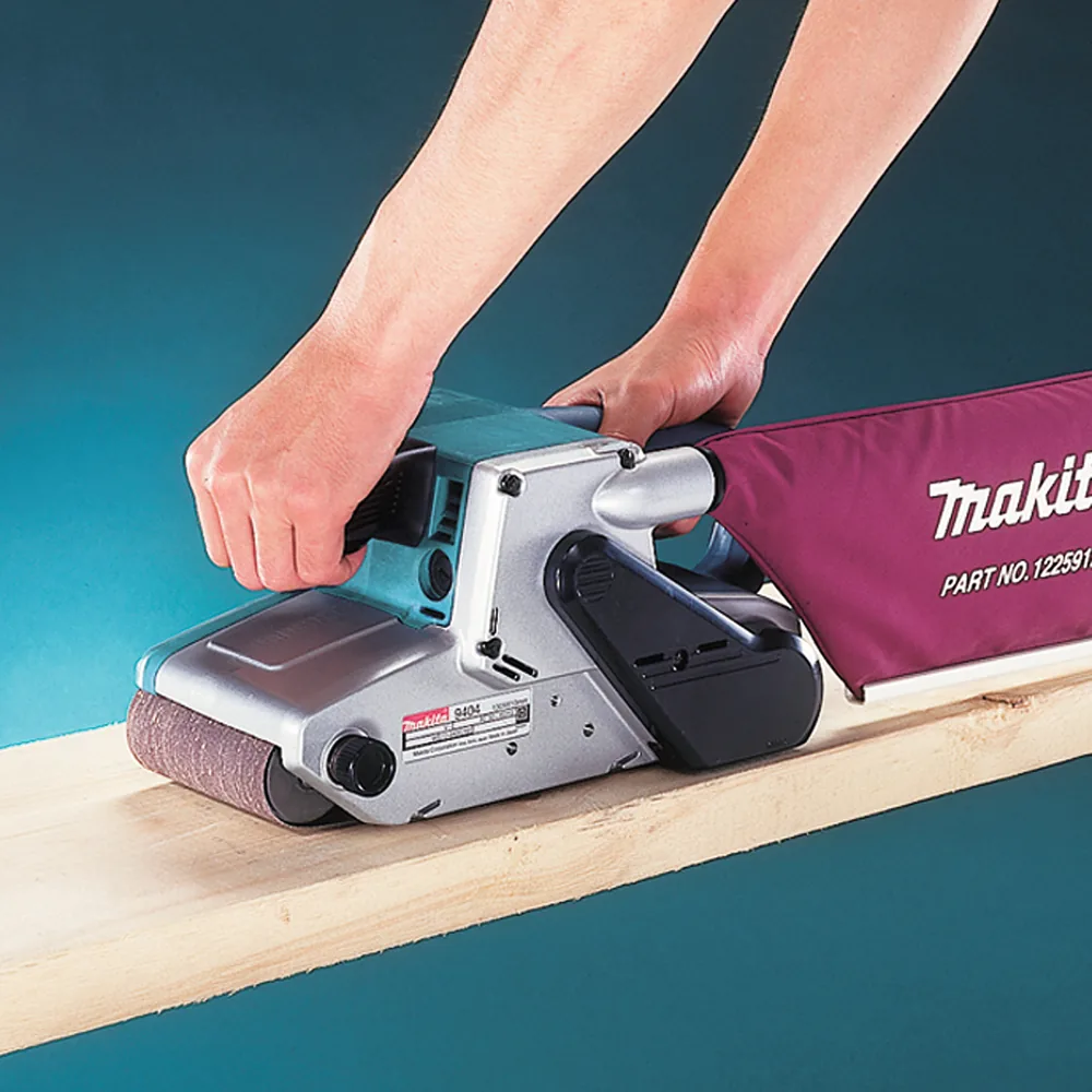 Makita 9404J Bandschleifer im Einsatz beim Schleifen eines Holzbretts