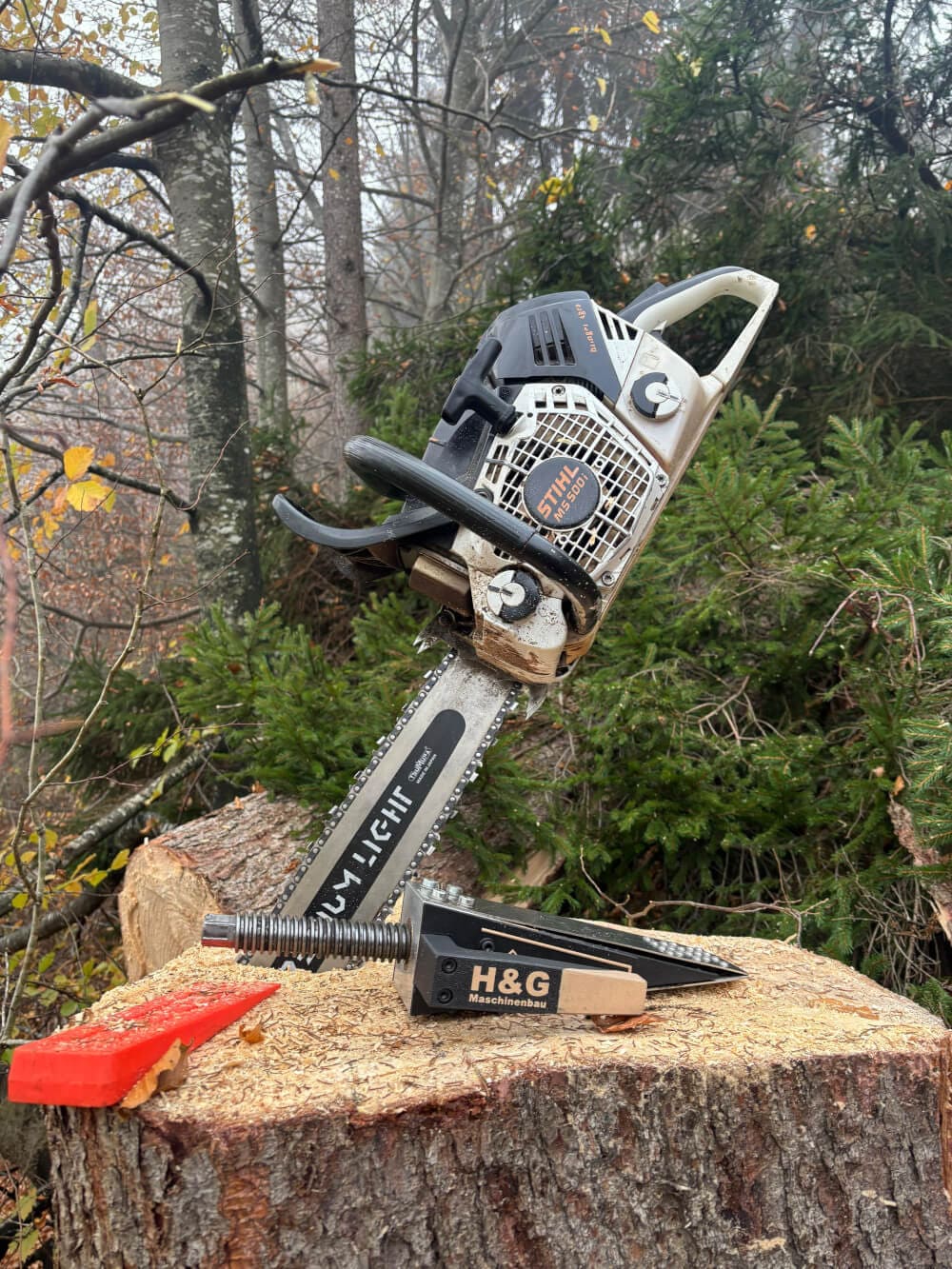 H&G Spindelkeil X6030 bereit zum Einsatz neben einer Motorsäge im Wald