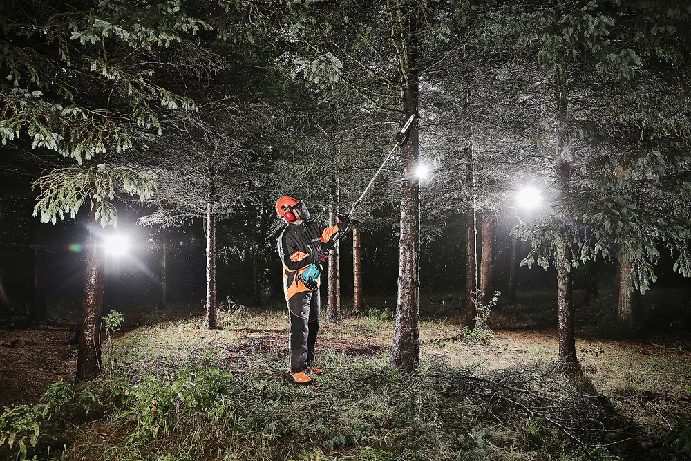 Makita DUX60Z mit Hochentaster-Aufsatz im nächtlichen Wald im Einsatz