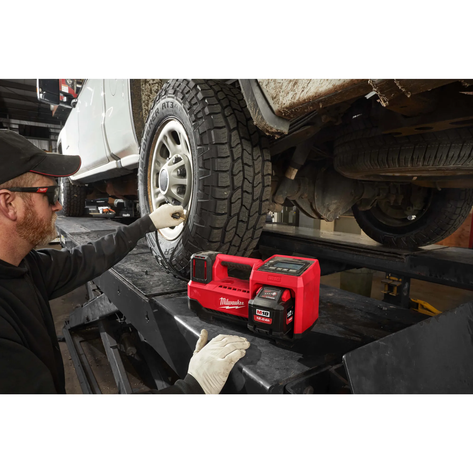 Mann füllt mit dem Milwaukee M18 BI-0 einen Pkw-Reifen auf