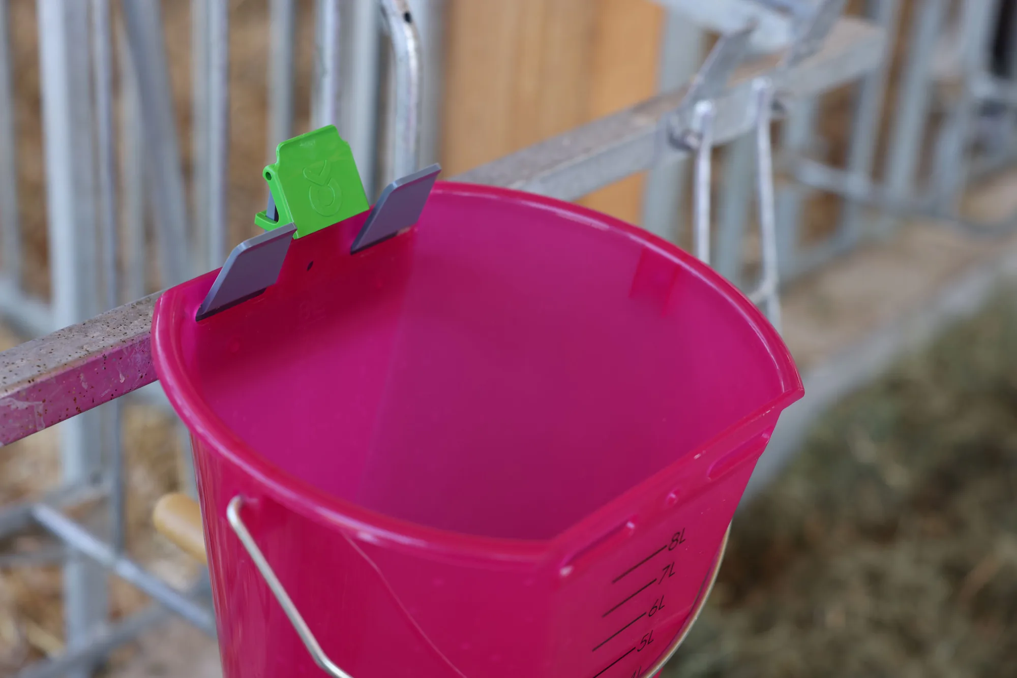 Pinker Eimer mit grünem Bucket-Guard-Halter eingehängt