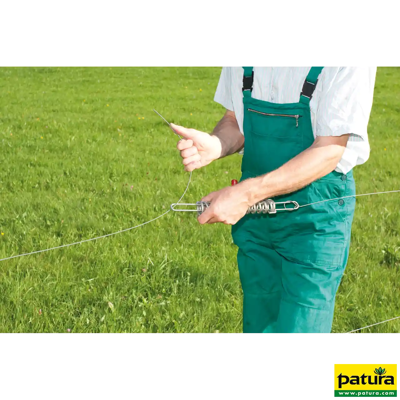 Mann montiert die Patura Stahlspannfeder am Zaundraht