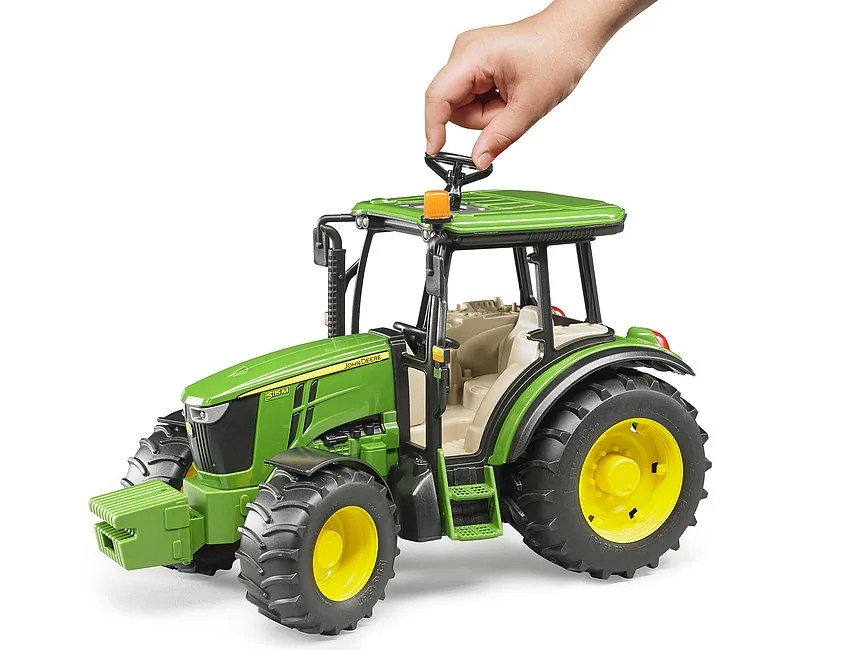 Kind lenkt den Bruder Traktor mit der Zusatz-Lenksäule durch das Schiebedach