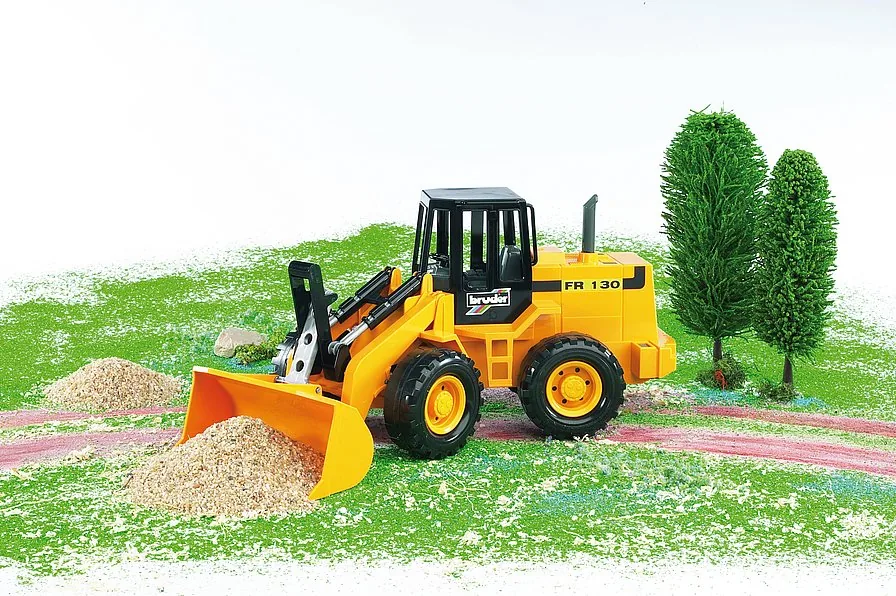 Bruder Radlader beim Schaufeln von Sand auf einer Spielzeug-Baustelle