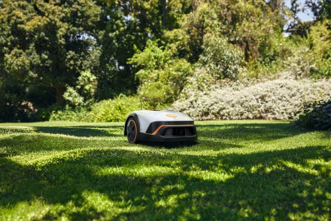 STIHL iMOW 4 Mähroboter im Garten auf sonnigem Rasen