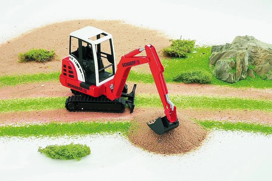 Bruder Minibagger im Einsatz: Graben von Sand auf der Baustelle im Freien