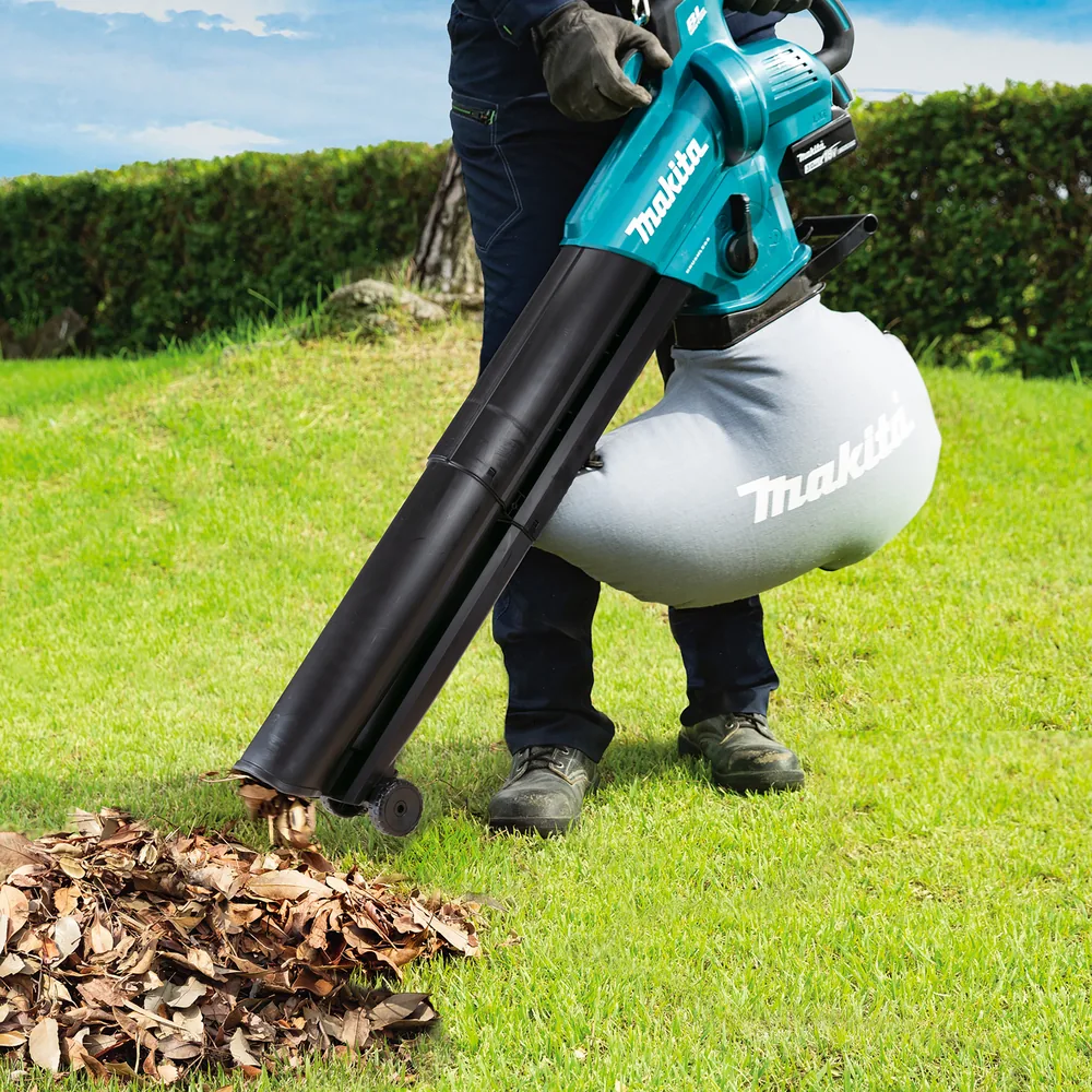 Mann saugt mit dem Makita DUB187 Laub vom Rasen