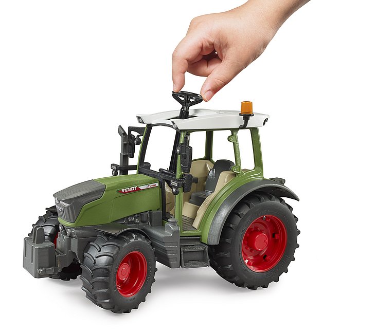 Kind steuert den Fendt Traktor mit der Zusatzlenkstange durch das Schiebedach