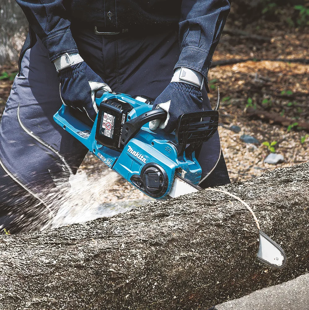 Makita DUC353Z Kettensäge beim Sägen eines Stamms mit fliegenden Spänen