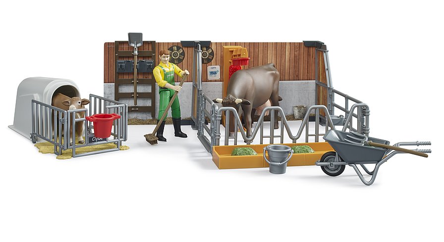 Kuh steht am Futtertrog im Bruder Stall mit Melkmaschinen-Attrappe und Bauer