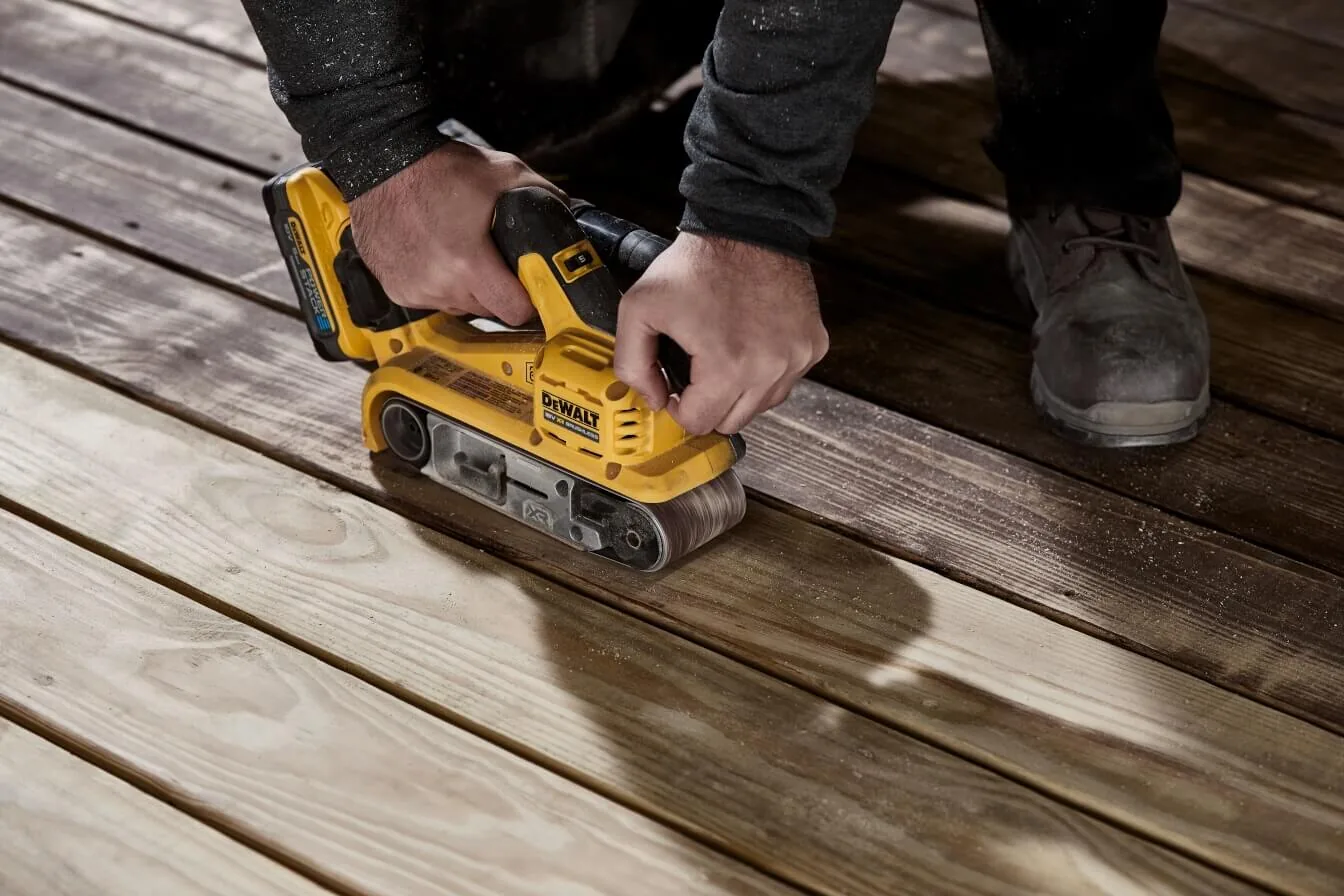 DeWalt DCW220NT Akku-Bandschleifer im Einsatz auf einer Holzterrasse