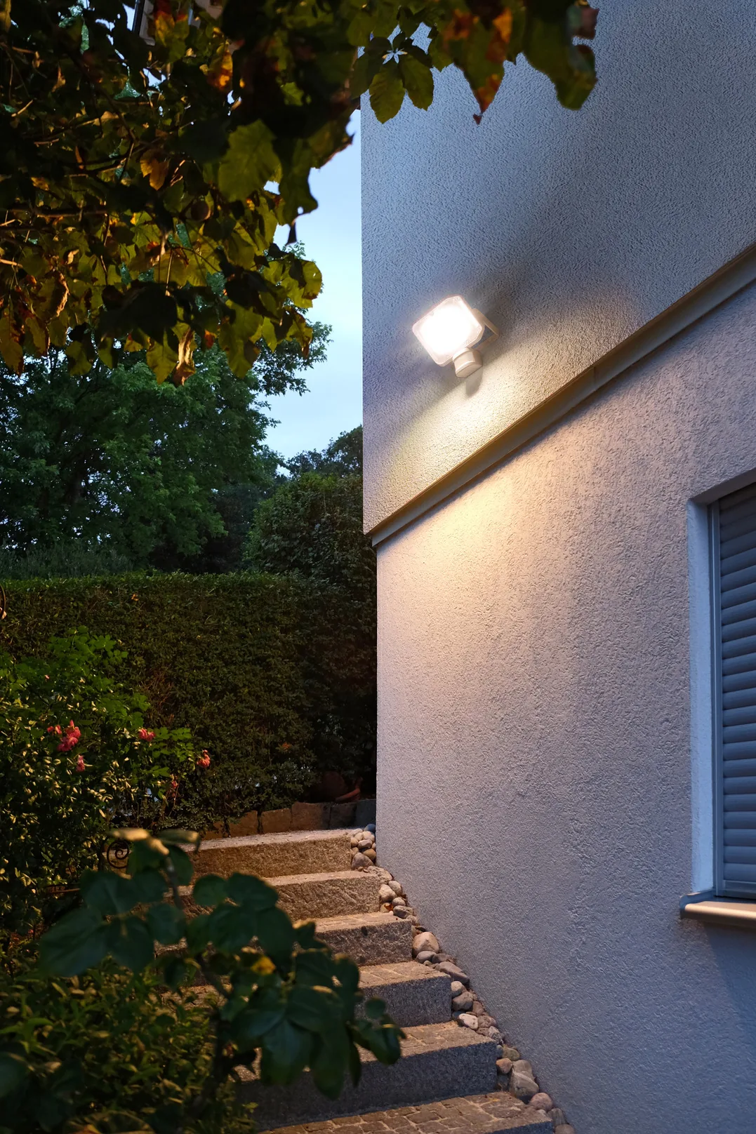 Brennenstuhl LED Strahler AL 2050 PIR an einer Hauswand bei Dämmerung im Einsatz