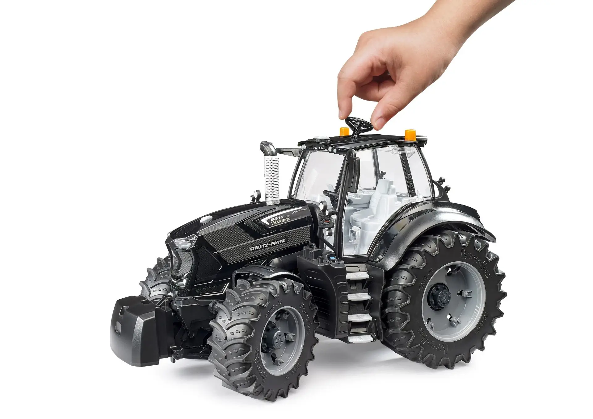 Hand spielt mit dem BRUDER DEUTZ-FAHR 8280 TTV Warrior Spielzeugtraktor
