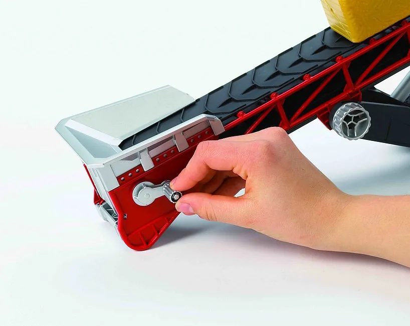 Kind bedient die Handkurbel zum Transport von Material auf dem Bruder Förderband