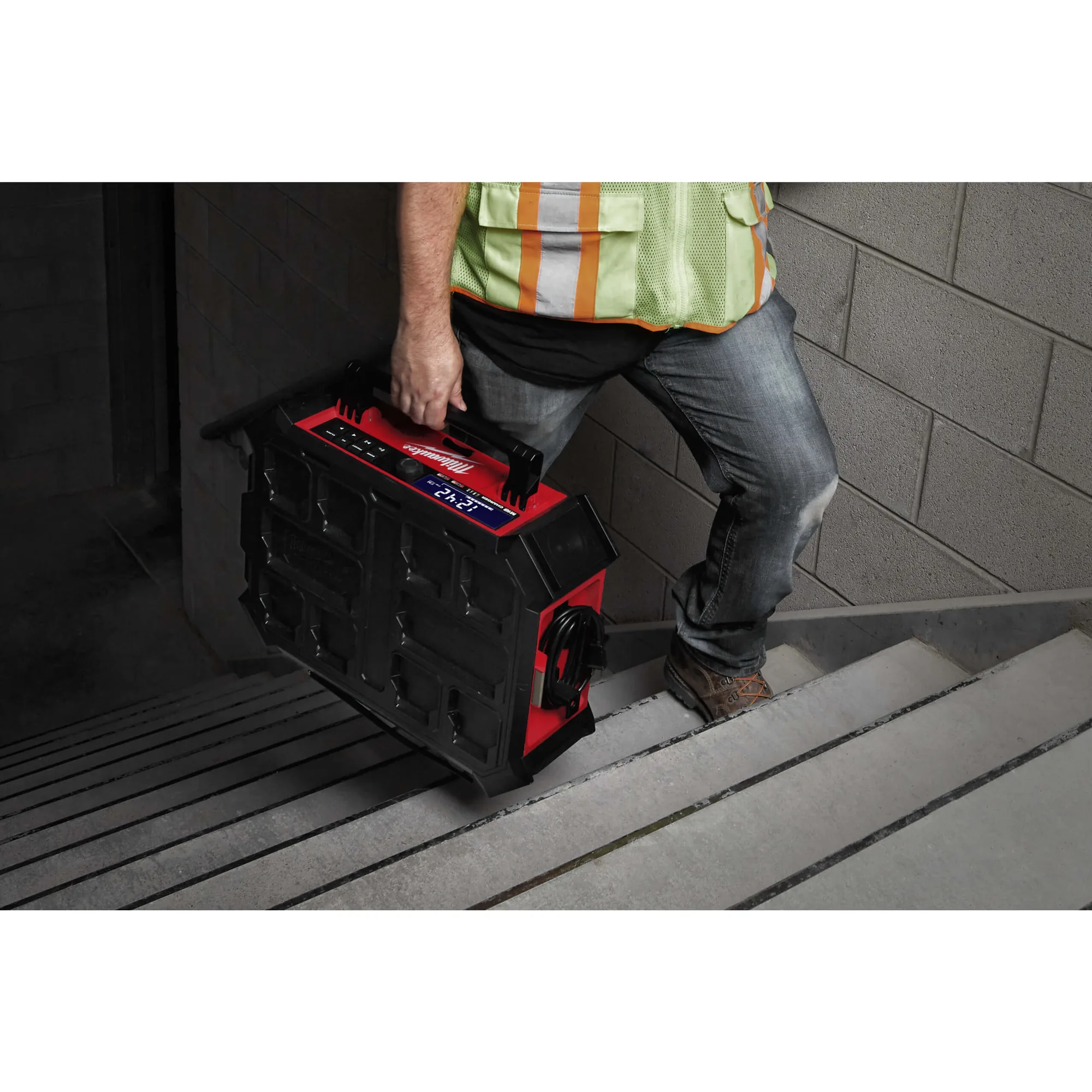 Milwaukee M18 PRCDAB PackOut Radio wird am Tragegriff getragen