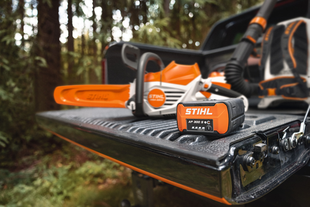 Stihl4 STIHL Akku-Kettensäge und Ladegerät im Pickup auf Forstweg