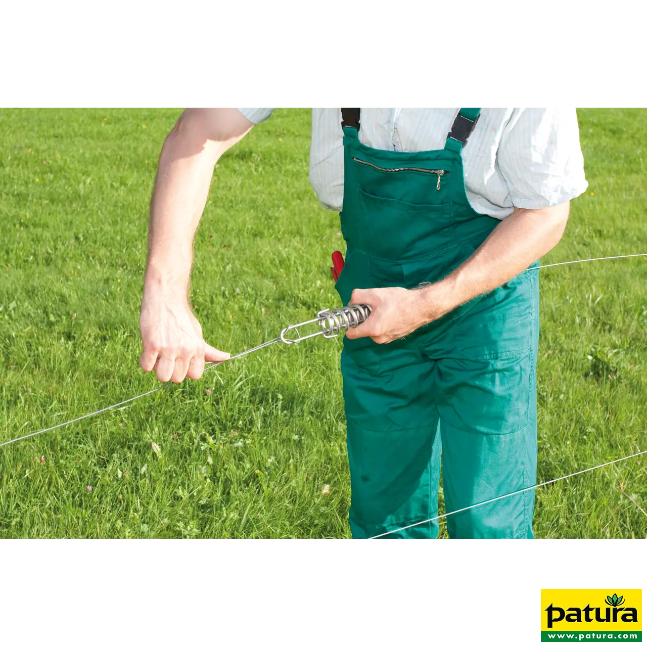 Mann spannt die Patura Stahlspannfeder am Zaundraht