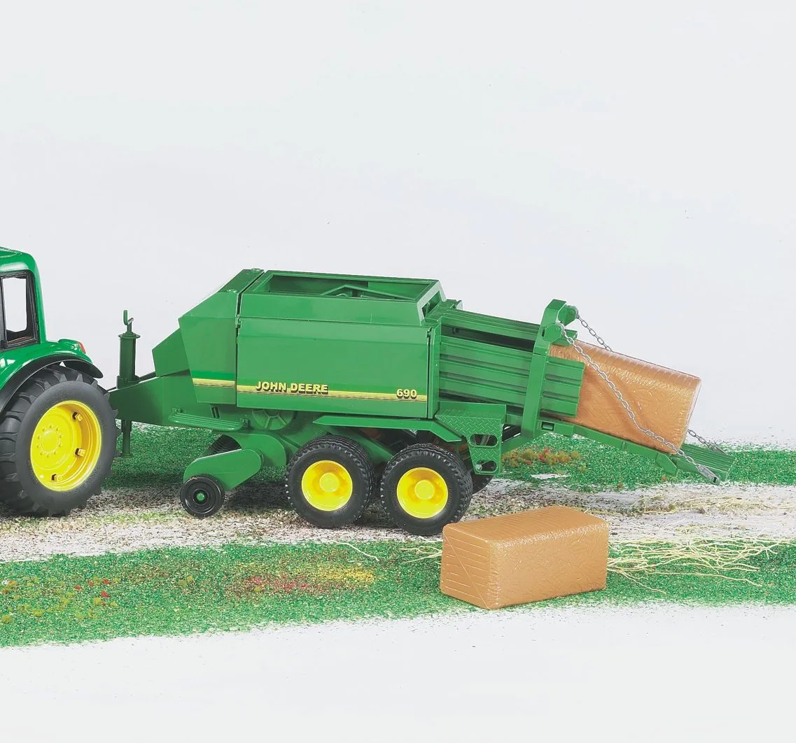 John Deere Ballenpresse von Bruder im Spieleinsatz am Traktor angehängt