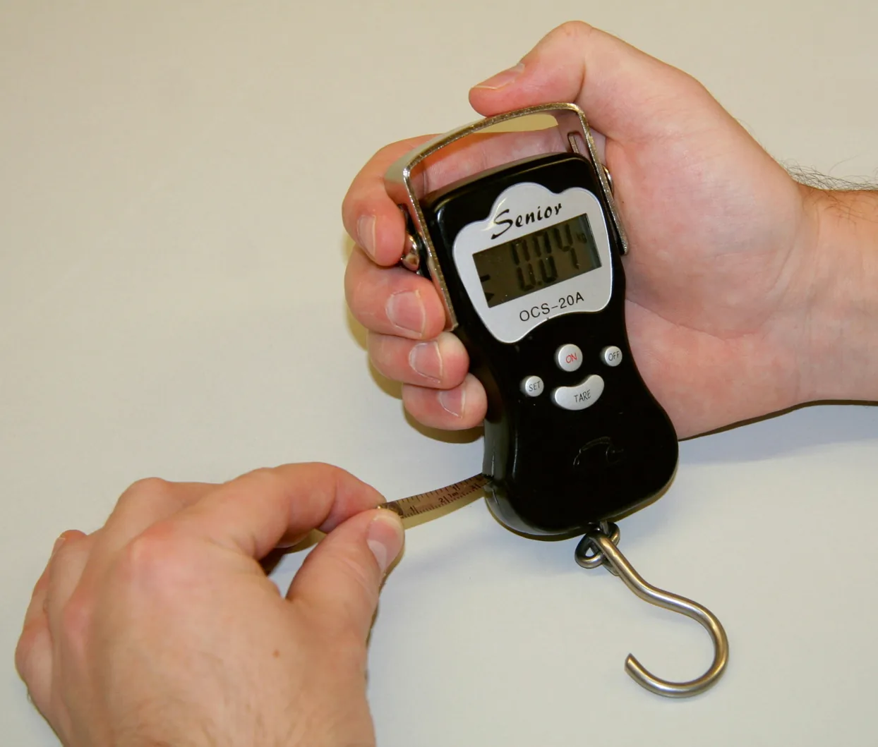 Hand hält die schwarze digitale Kerbl DigiScale 50 Hängewaage