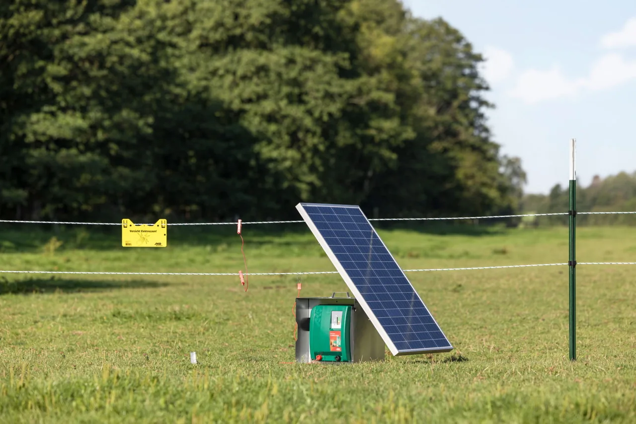 Duo Power X 6000 mit Solarpanel am Weidezaun, Wald im Hintergrund