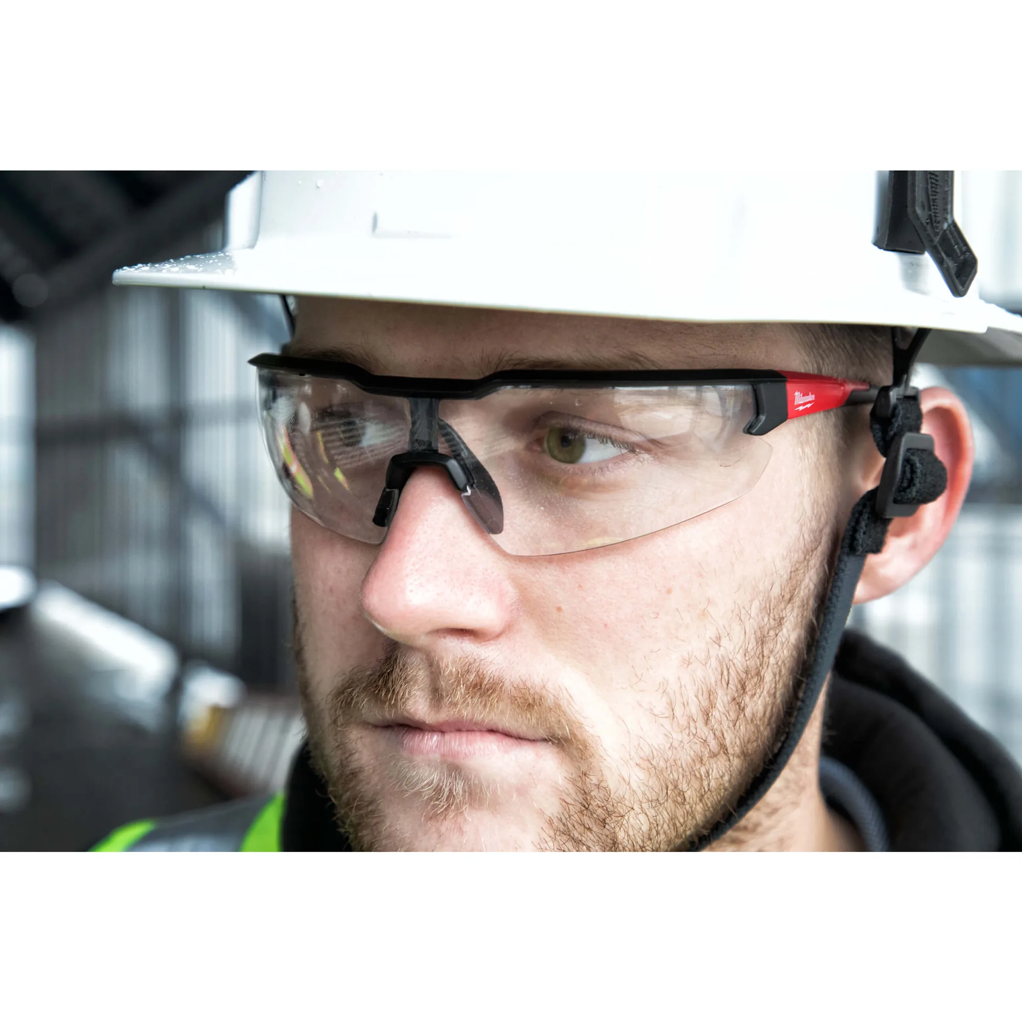 Mann mit Helm und Milwaukee Schutzbrille auf einer Baustelle
