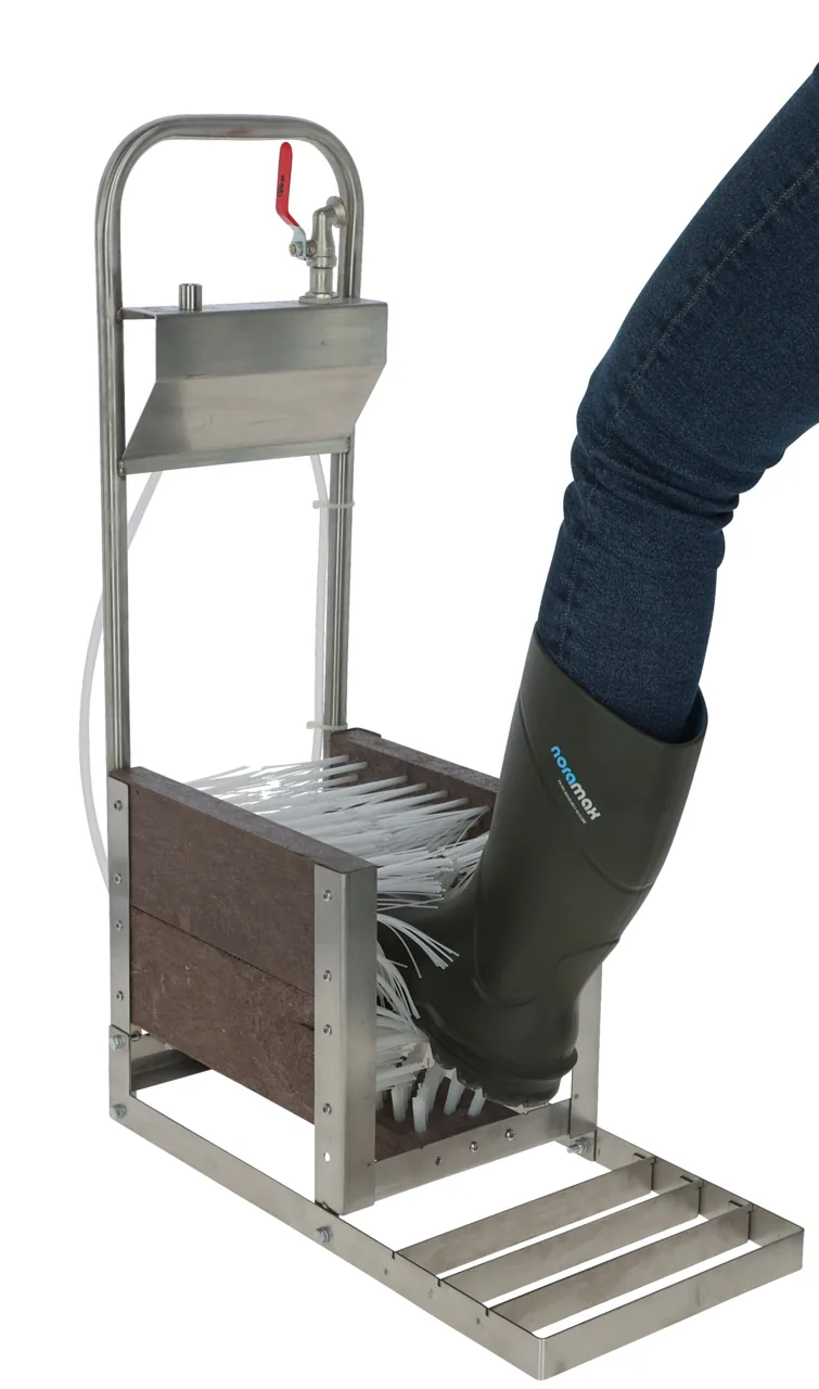 Person reinigt Gummistiefel am Stiefelreiniger, freigestellt