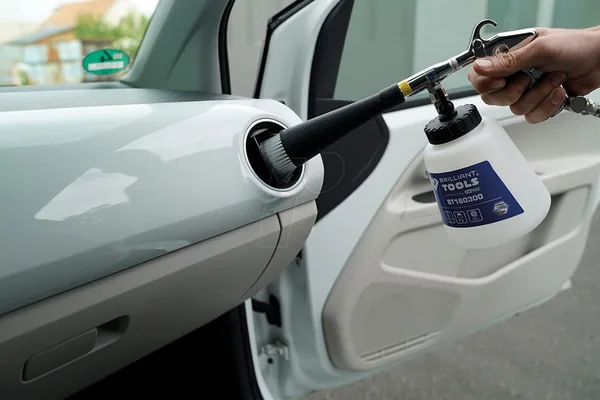 KS Tools Druckluft-Reinigungspistole 160300 reinigt eine Auto-Türverkleidung