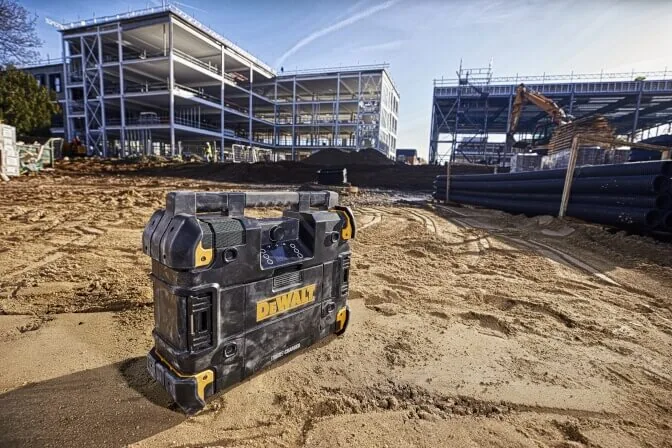 DeWalt DWST1-81078 TSTAK Baustellenradio im Sand vor einer Baustelle