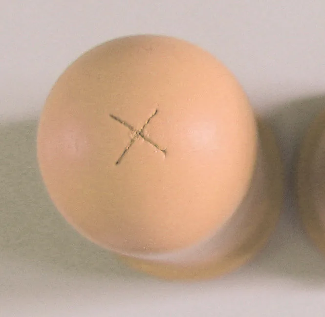 Braunes Hühnerei mit eingeritzter X-Markierung