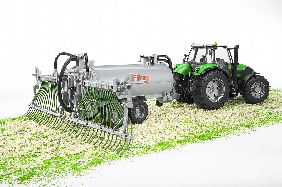 Bruder Fliegl Fassanhänger angehängt an einen Traktor beim Düngen auf dem Feld