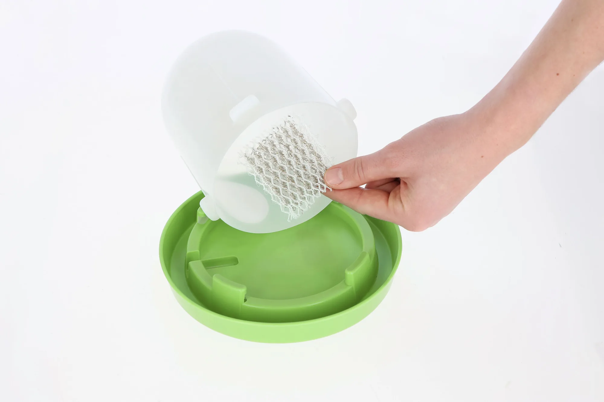 Hand legt die Silvertex Anti-Keim-Matte auf den grünen Tränkenteller