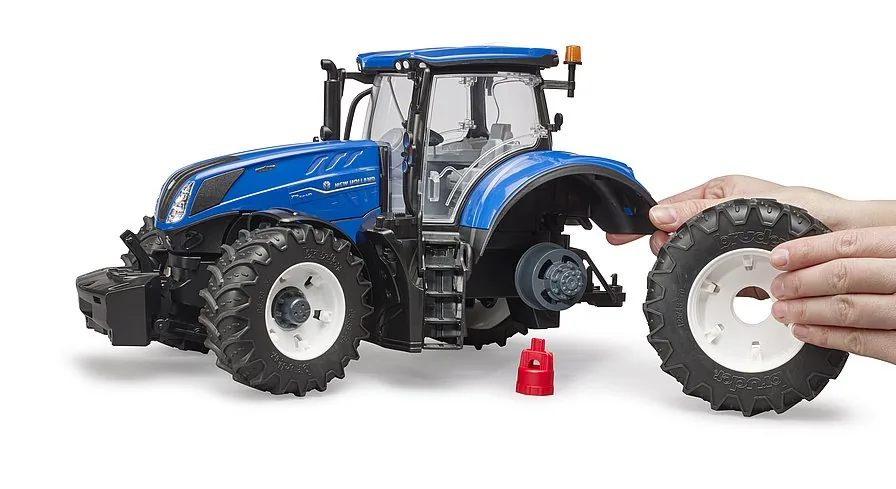 Spielszene: Kind wechselt das Hinterrad des Traktors mit dem roten Montageschlüssel