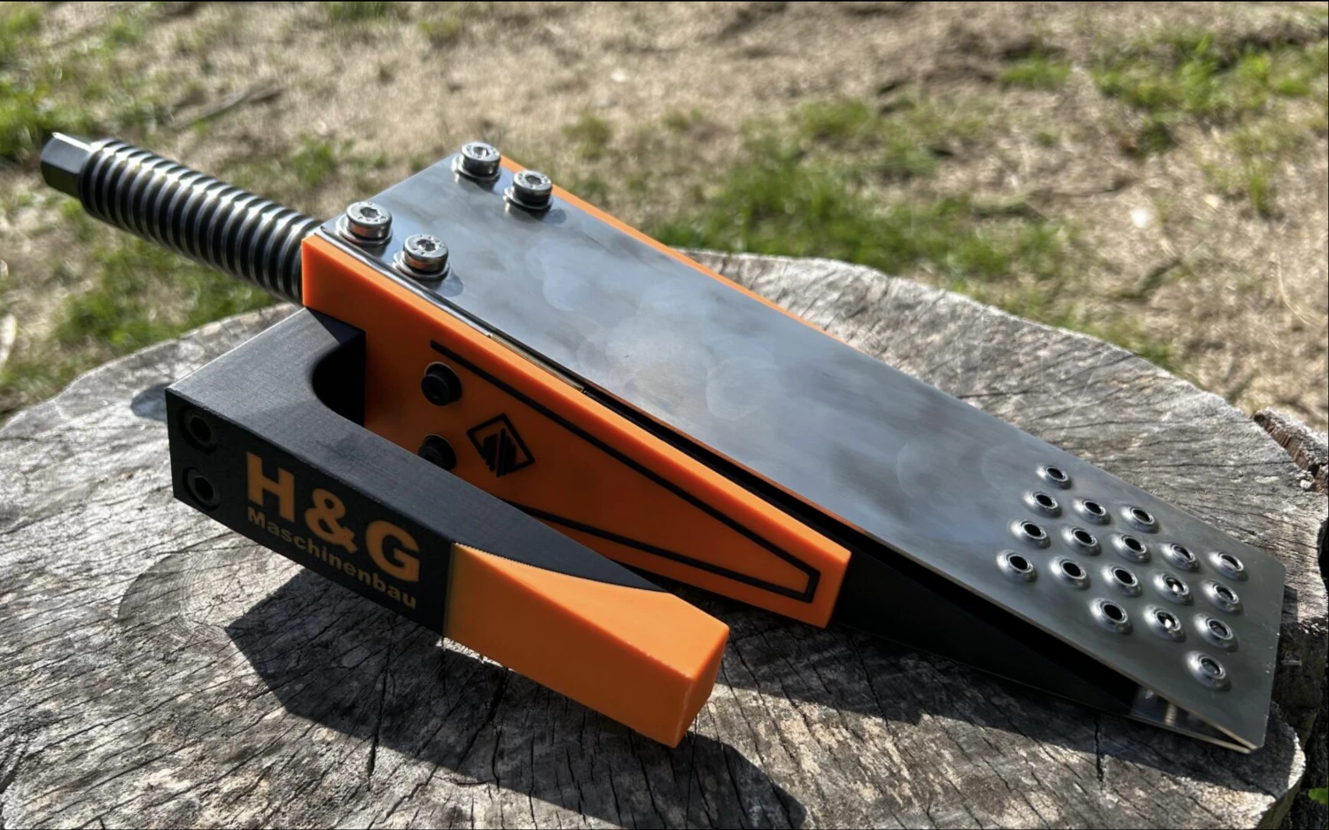 Forstkeil X6030 Spindelkeil in Schwarz-Orange auf einem Baumstumpf