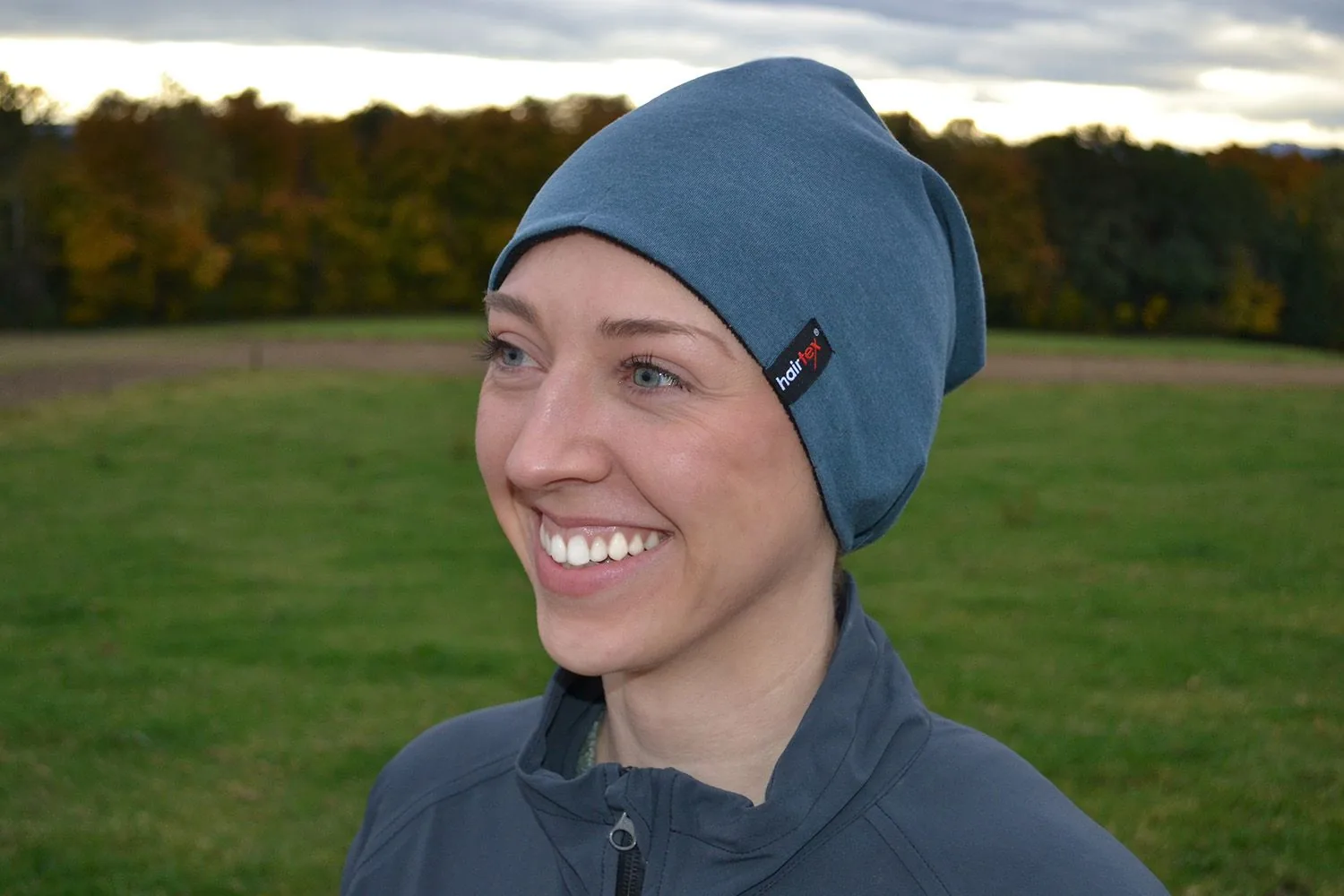 Frau im Profil mit ozeanblauem Hairtex Winter-Stall-Beanie im Herbst