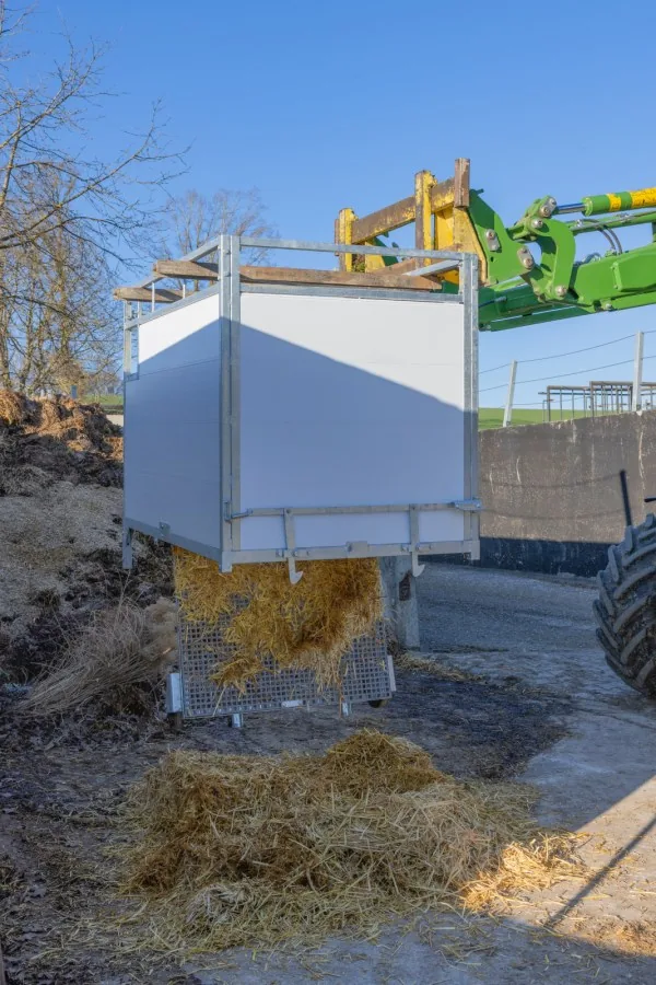 Kerbl Kälberbox Premium mit schwenkbarem Boden auf dem Hof, beim Entleeren
