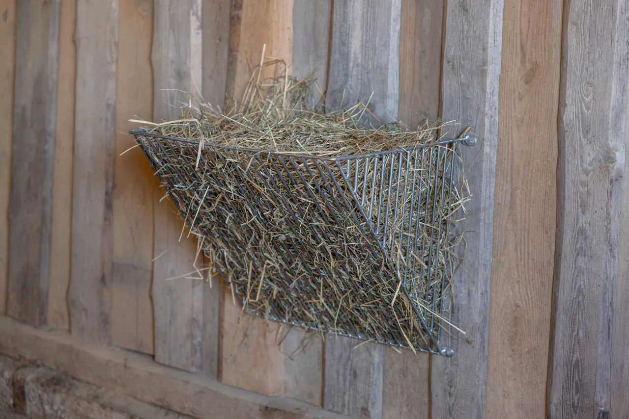 Verzinkte Kerbl Futtersparraufe mit Heu an einer Holzwand