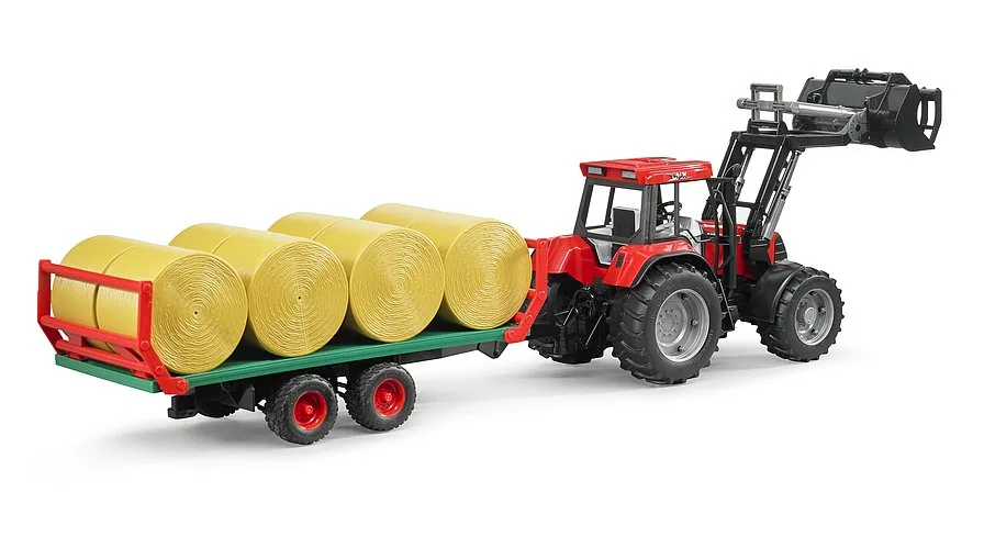 Bruder Traktor zieht den voll beladenen Ballenanhänger vom Feld