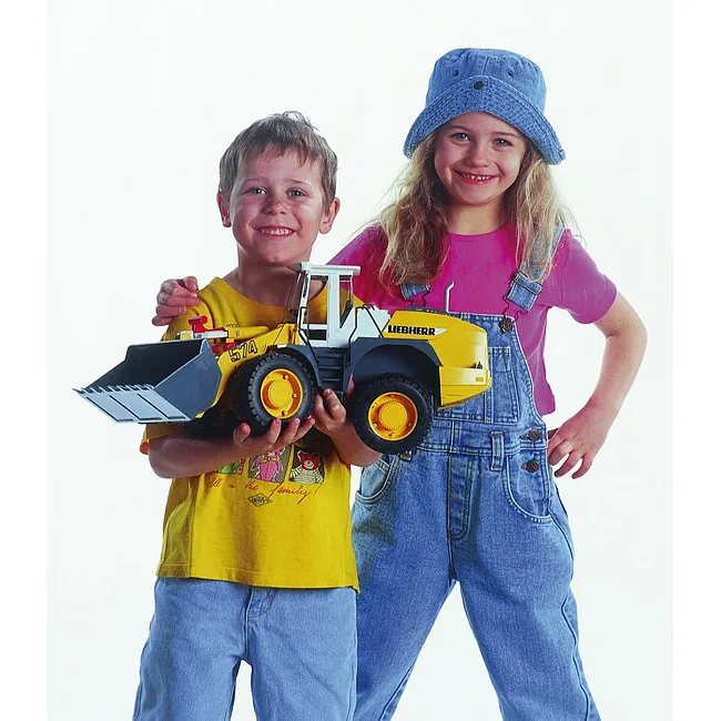 Zwei Kinder halten ein gelbes BRUDER Liebherr Radlader-Modell L574