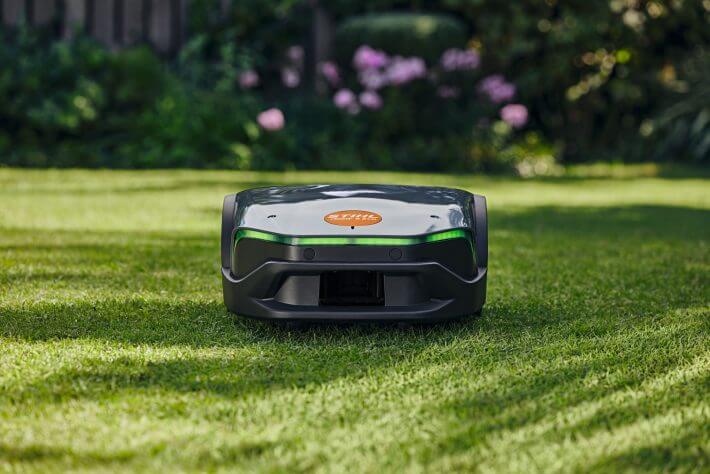 STIHL iMOW 6 EVO Mähroboter im Garten in der Dämmerung