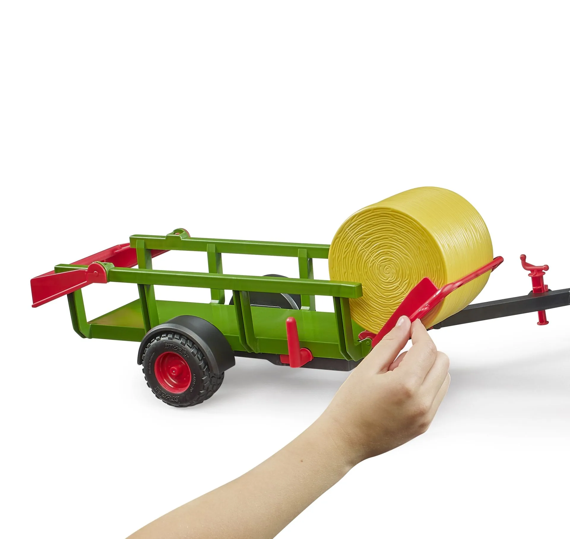 Hand bedient den Kippmechanismus des Bruder 02204 Rundballensammlers