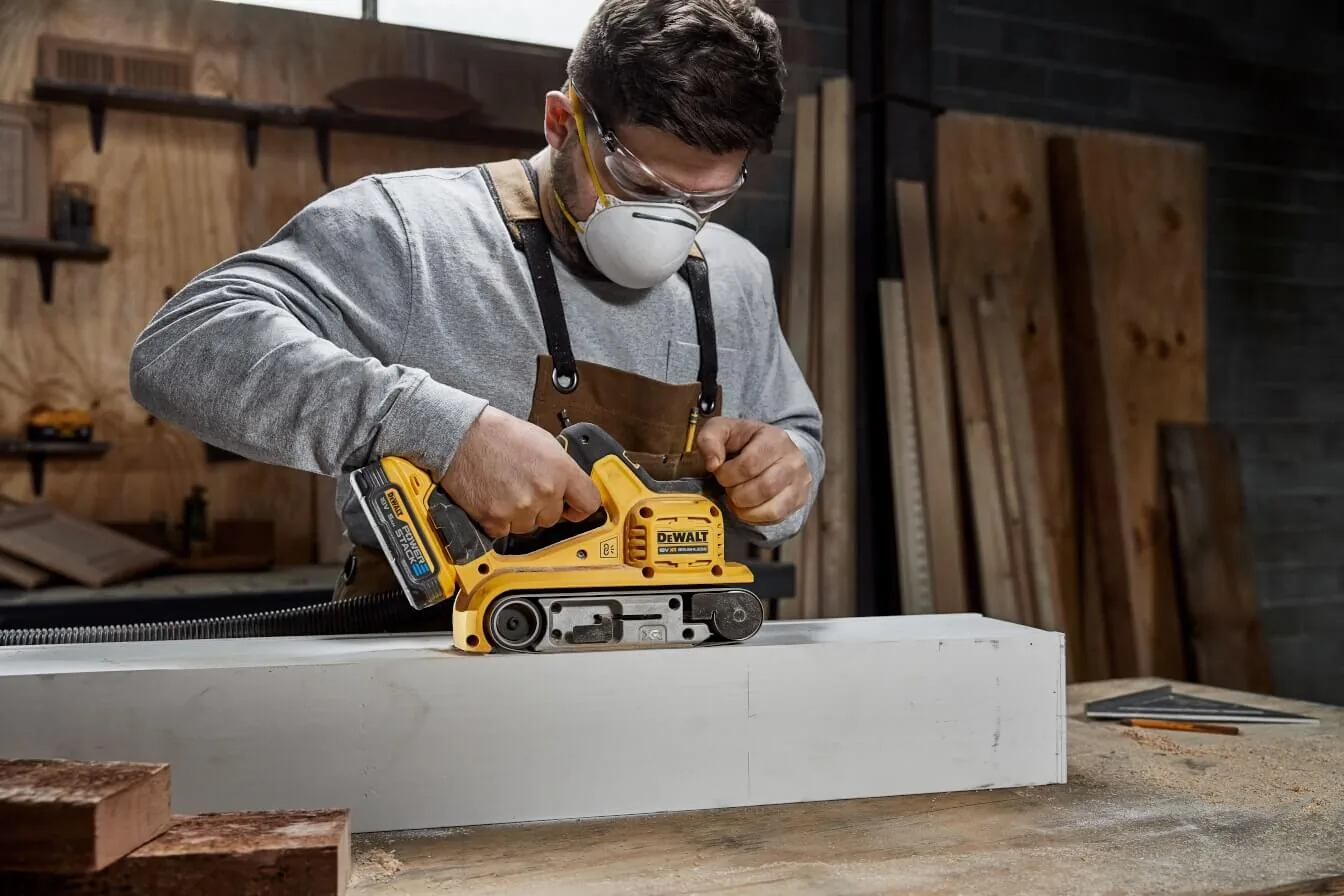 DeWalt DCW220NT Akku-Bandschleifer im Einsatz an einer Holzleiste