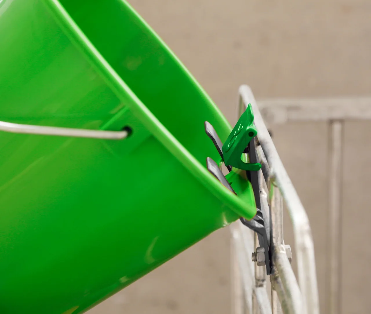 Grüner Kerbl Kälbertränkeeimer mit Bucket-Guard-Halter am Gitter