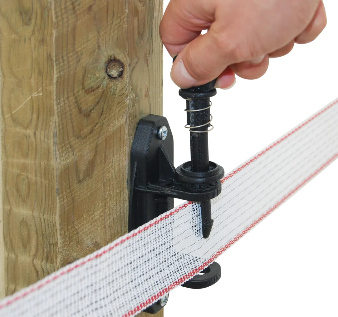 Hand spannt das Weidezaunband am Kerbl Premium Multi Spannisolator (Pfosten)